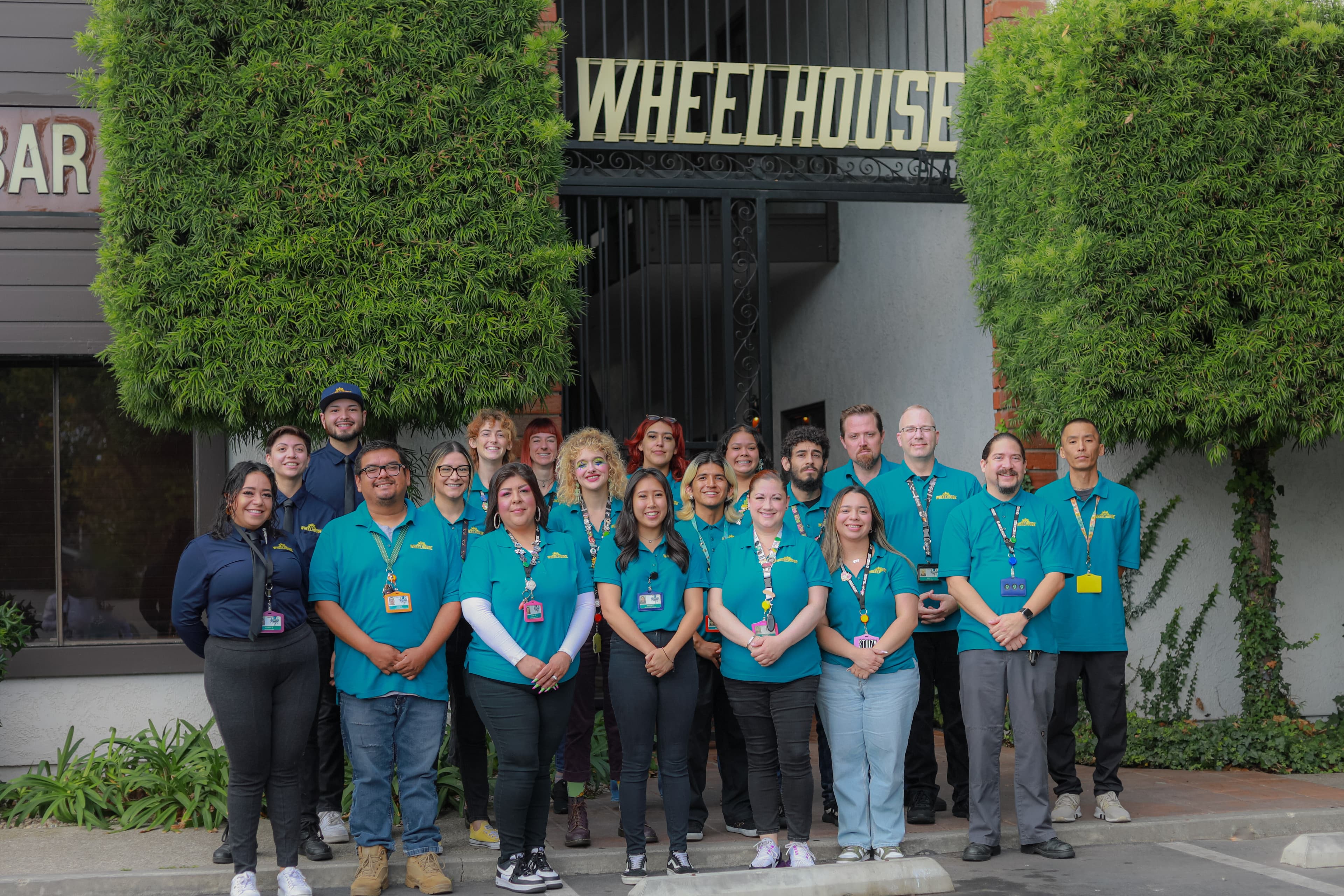 The Wheelhouse dispensary team gathered outside their storefront under the Wheelhouse sign